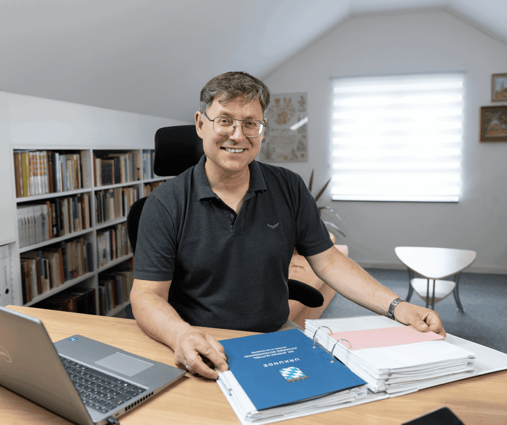 Matthias Wimmer sitzt lächelnd am Schreibtisch im Büro