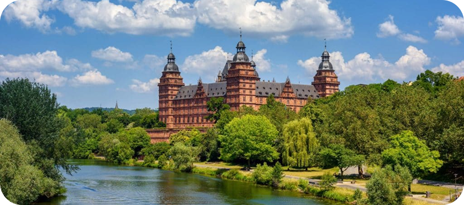 Blick auf Schloss Johannisburg in Aschaffenburg mit grüner Parkanlage im Vordergrund