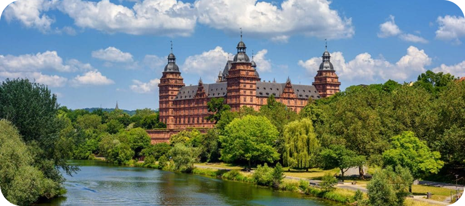 Blick auf Schloss Johannisburg in Aschaffenburg mit grüner Parkanlage im Vordergrund