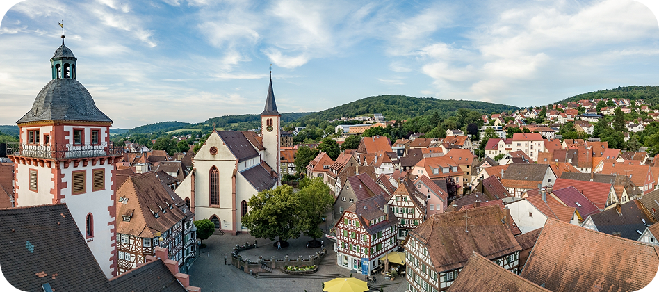 Blick auf eine Stadt mit Kirche und roten Dächern im Odenwald