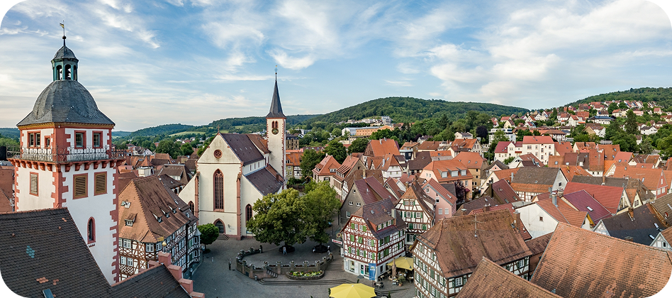 Blick auf eine Stadt mit Kirche und roten Dächern im Odenwald